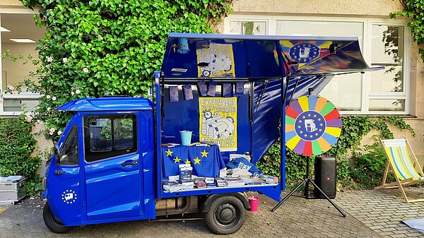 Ein kleiner blauer Lieferwagen mit Europa-Symbolen