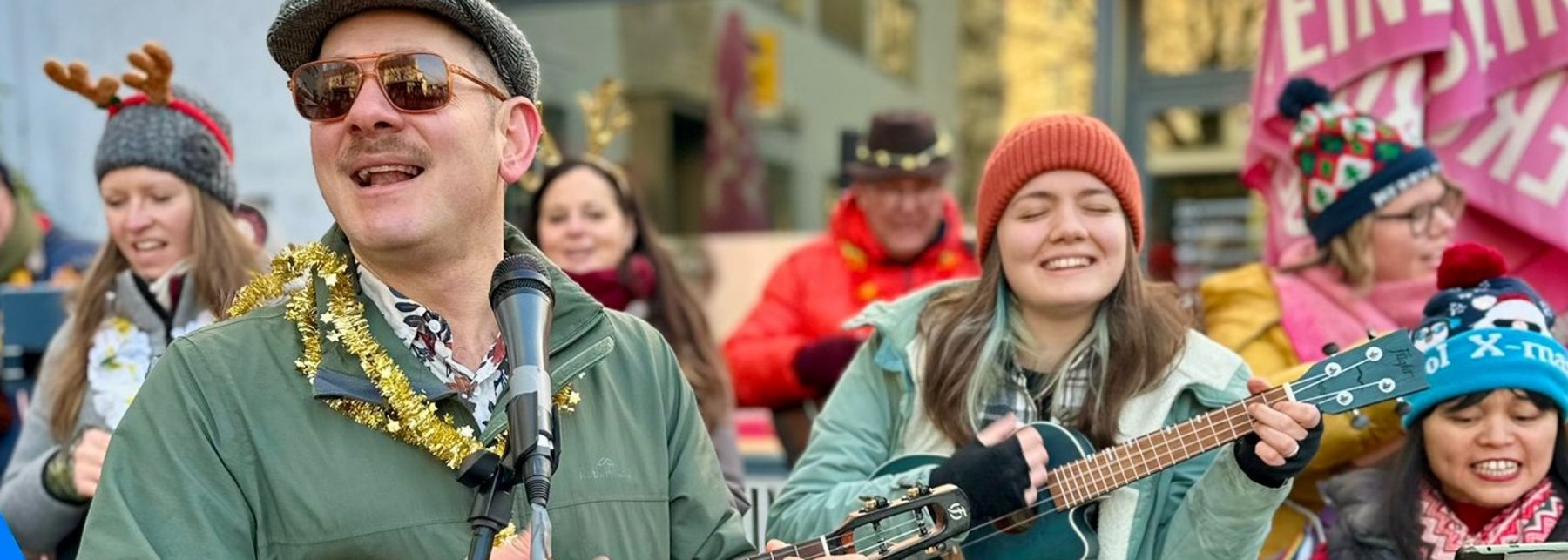 zwei Ukulele-Spieler*innen mit Weihnachtsdekoration