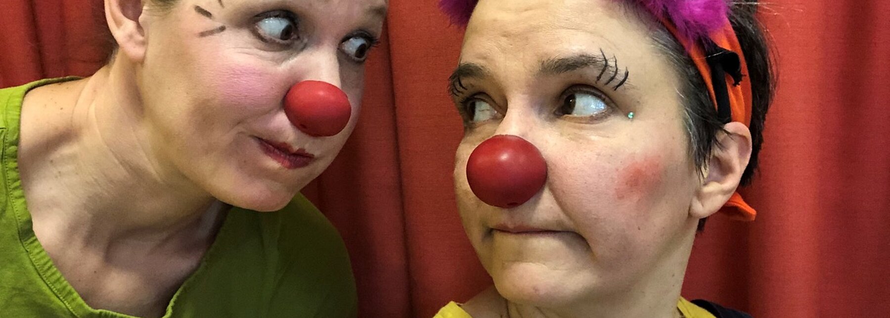 zwei Clowninnen vor rotem Vorhang