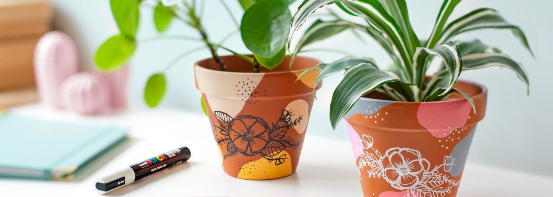 Mit bunten Stiften bemalte Tontöpfe