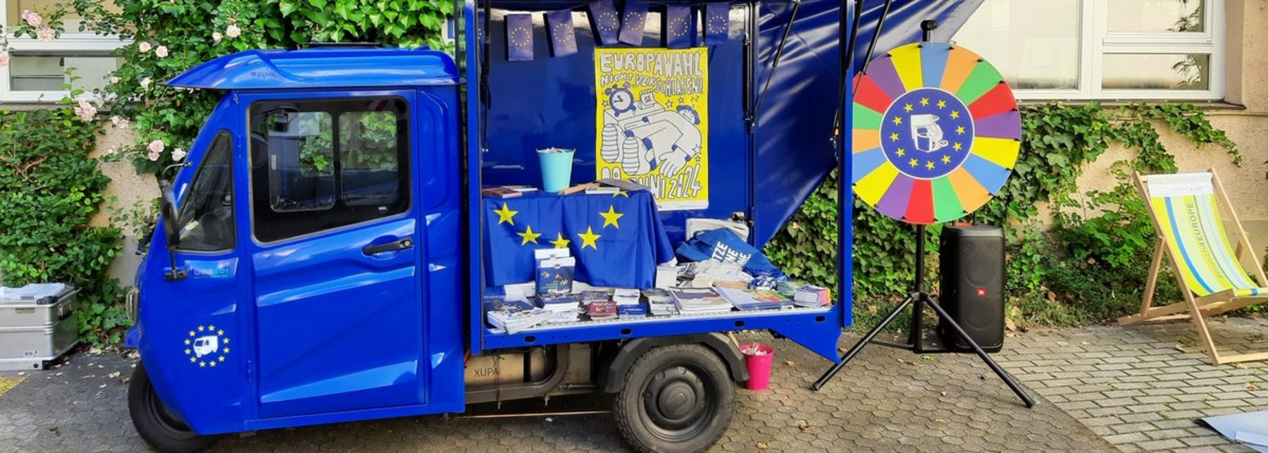 Ein kleiner blauer Lieferwagen mit Europa-Symbolen