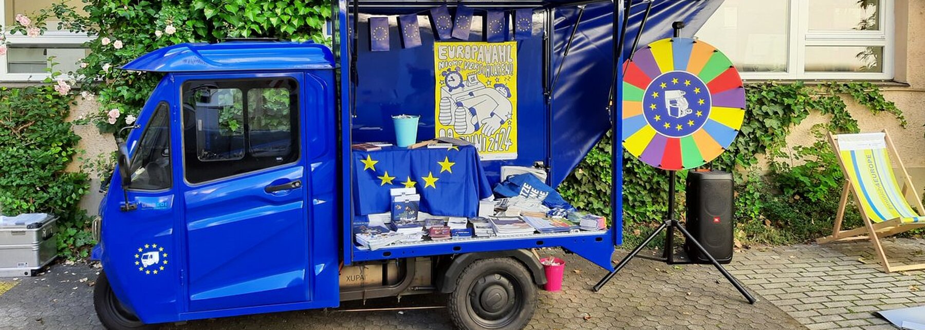 Ein kleiner blauer Lieferwagen mit Europa-Symbolen