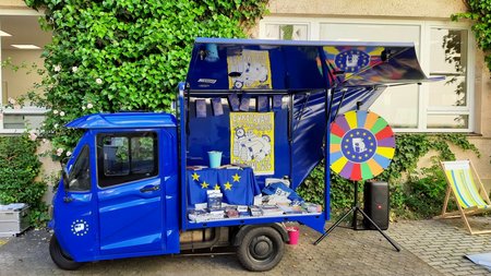 Ein kleiner blauer Lieferwagen mit Europa-Symbolen