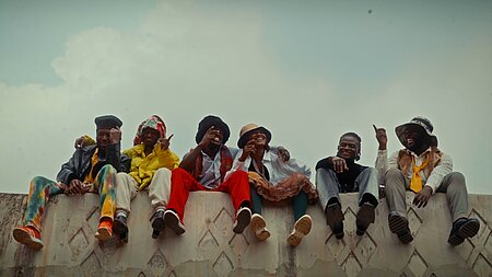 Junge Nigerianer*innen auf einer Mauer