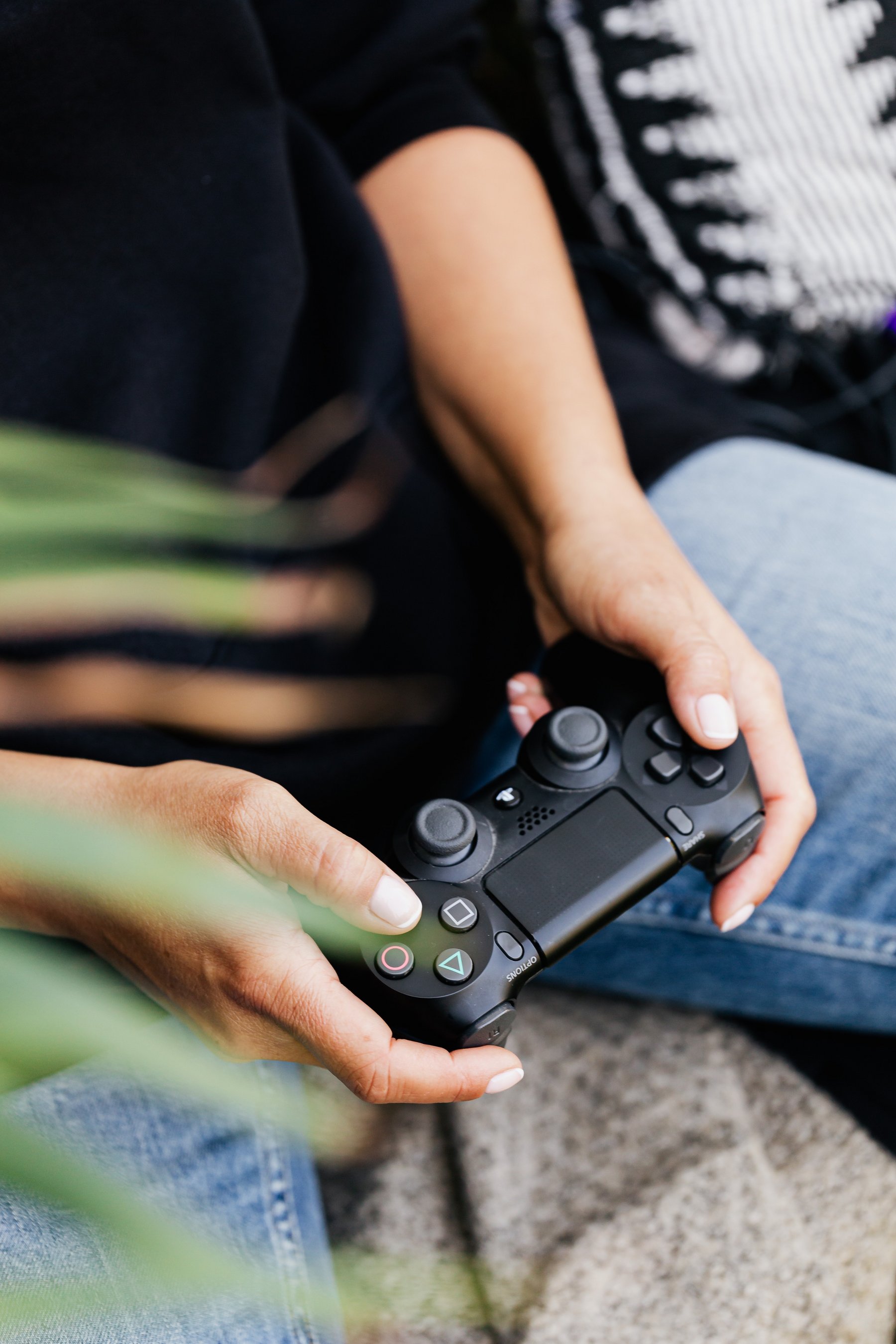 Zwei Hände halten einen Controller für eine Videospielkonsole.