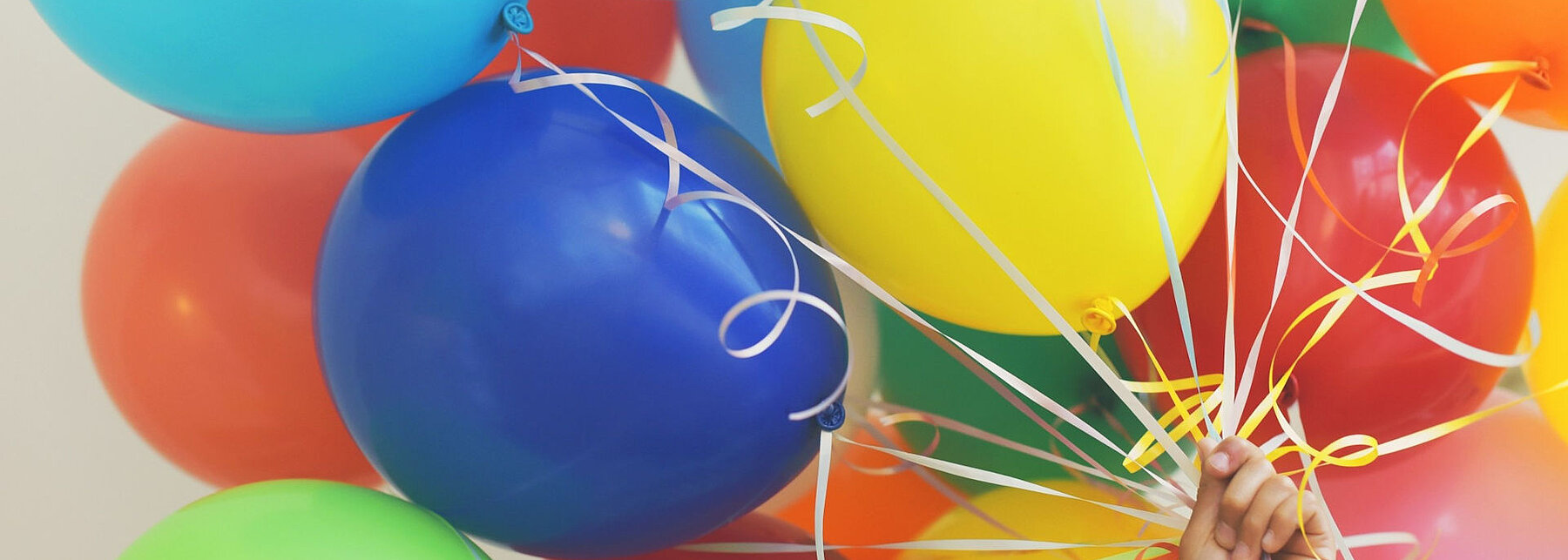 Hand hält Luftballons