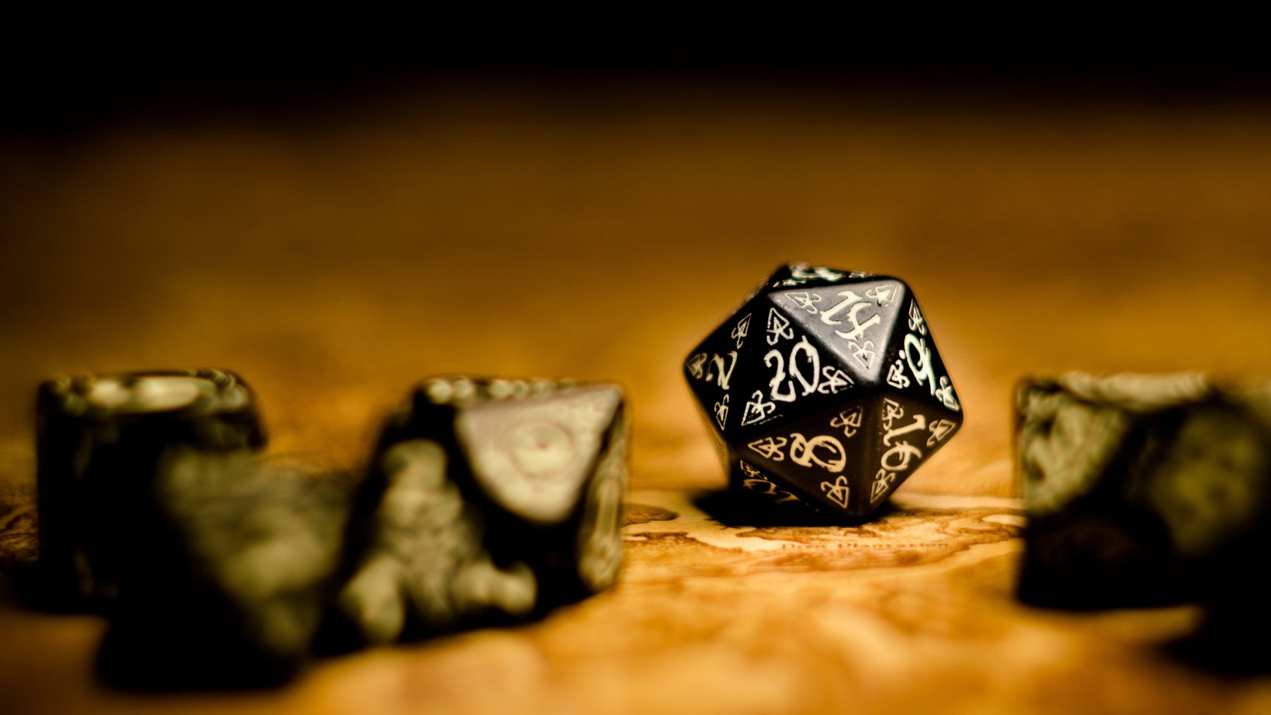 mehrere schwarze Würfel auf einem Spieltisch