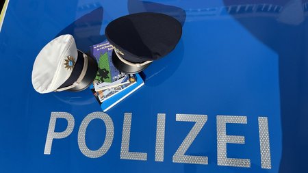 Polizeimützen und Bücher auf einem Polizeiauto