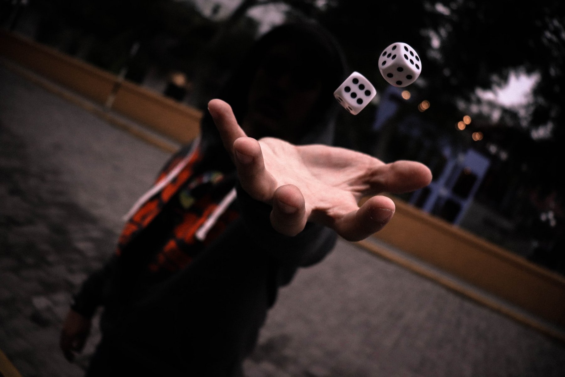 eine Hand wirft zwei Würfel hoch