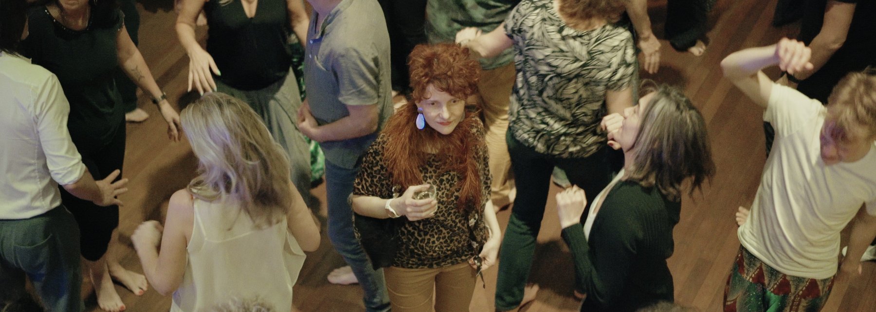 Ein Frau steht verloren zwischen Tanzenden auf der Tanzfläche