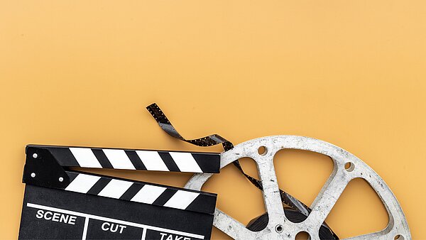 eine Filmklappe und eine Filmrolle