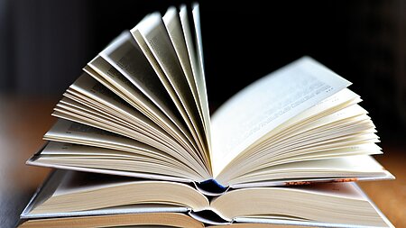 Bücherstapel aus aufgeschlagenen Büchern