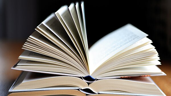 Bücherstapel aus aufgeschlagenen Büchern