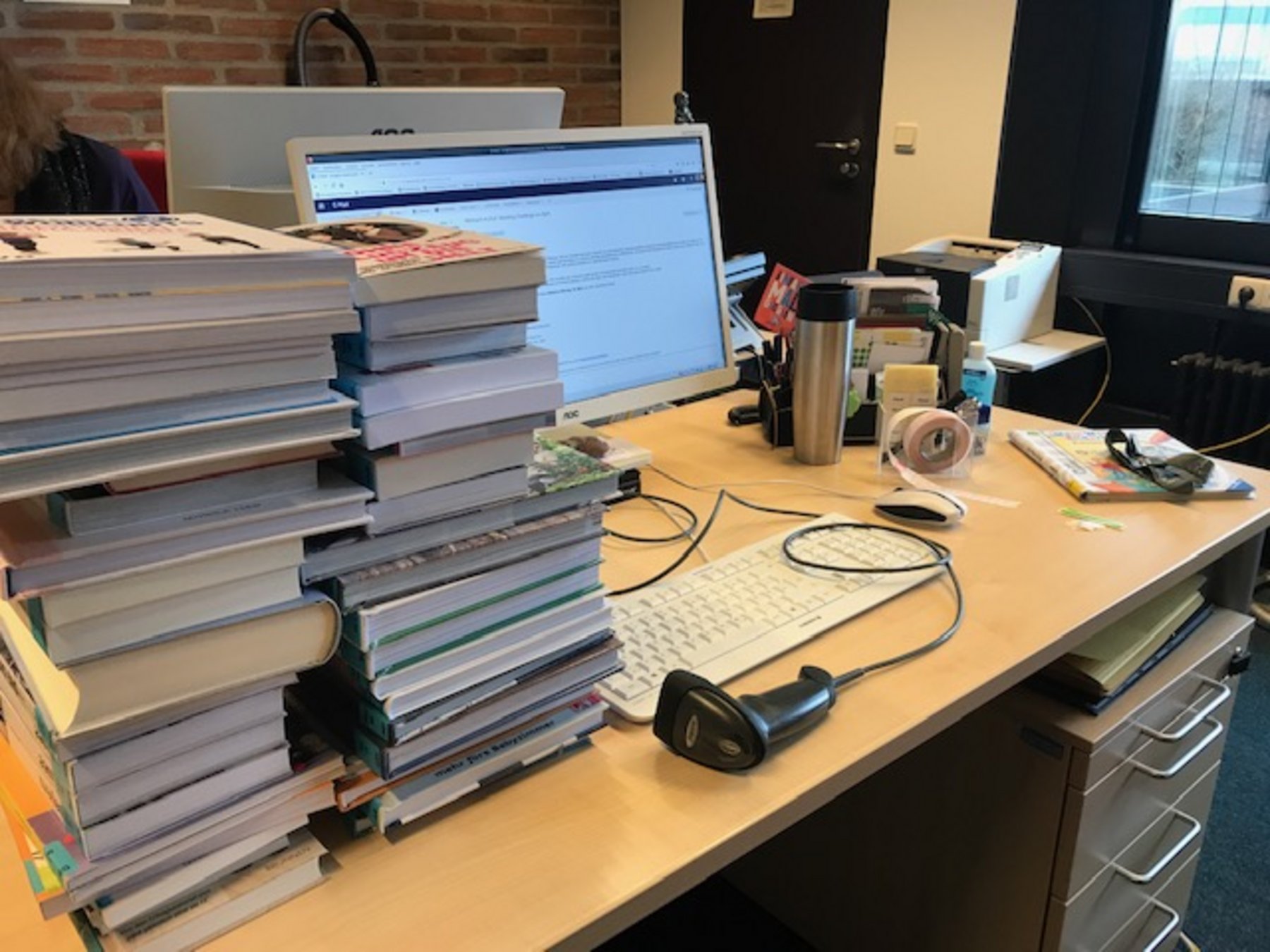 Schreibtisch mit Bücherstapeln