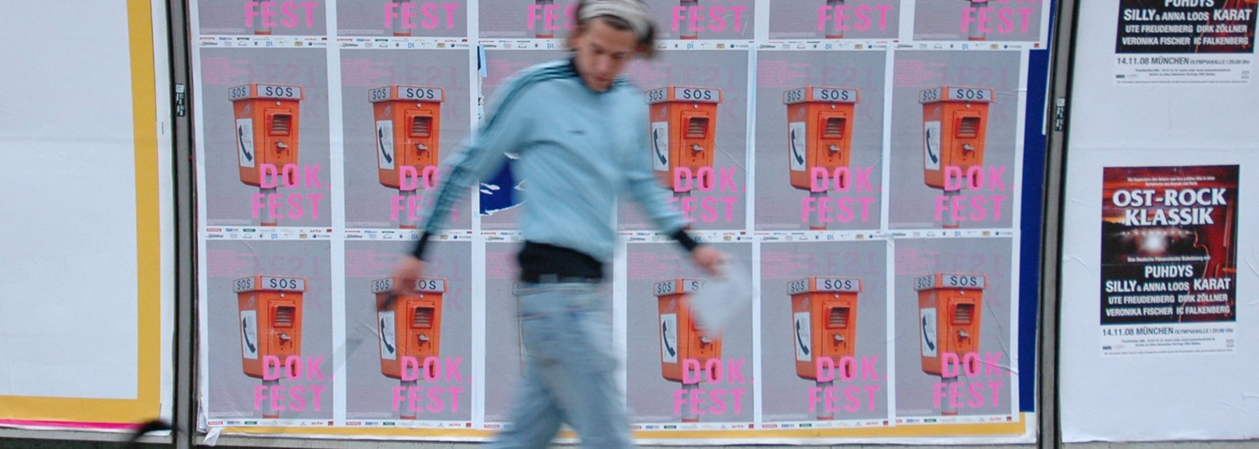 Mann vor einer DOK.fest-Plakatwand