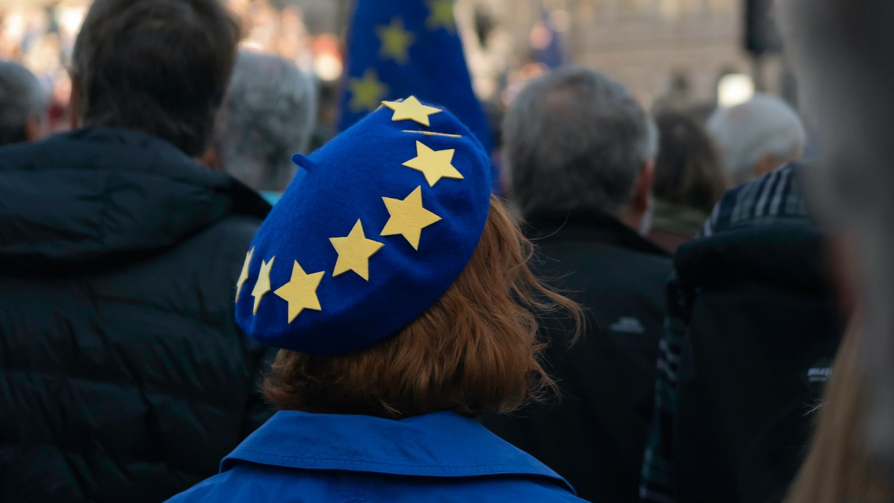 Person mit einer blauen Baskenmütze an die gelbe Europasterne geheftet sind
