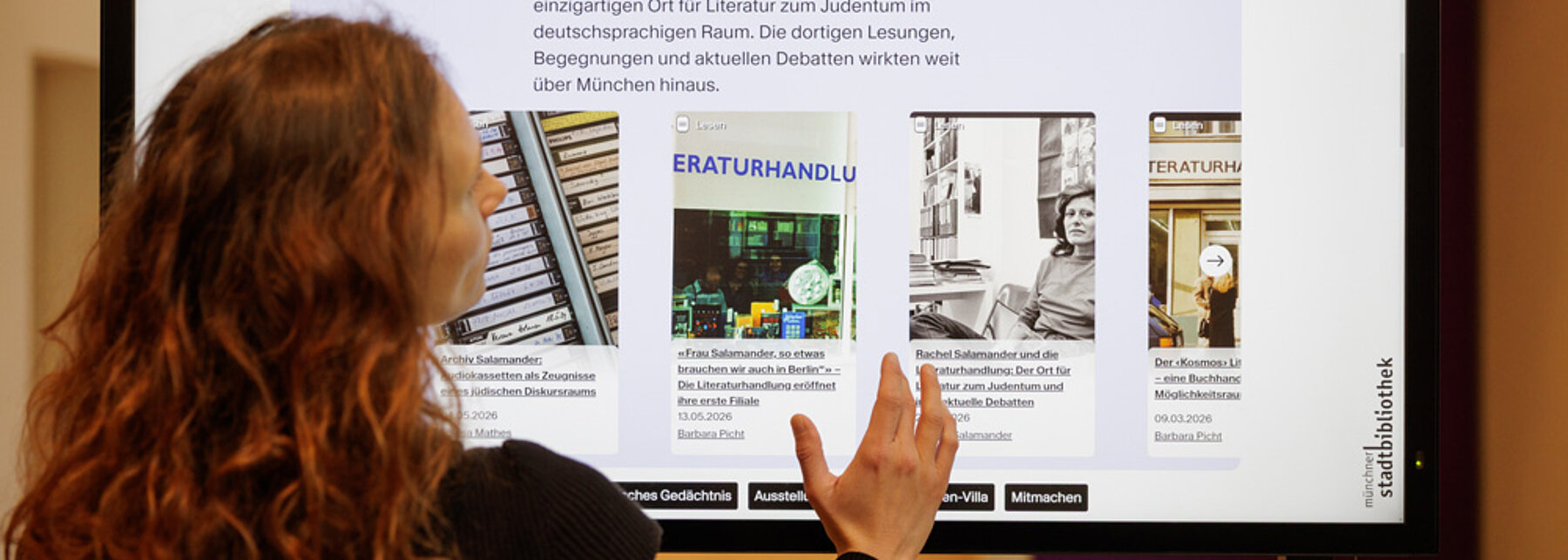 Multimediales Storytelling im MON Mag (c) Thomas Dashuber Großer Touch Screen Bildschirm. Das MON Mag ist aufgerufen mit einer Auswahl an Online Artikeln.