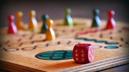 ein Mensch-Ärgere-Dich-Nicht-Spielbrett mit Figuren und Würfel