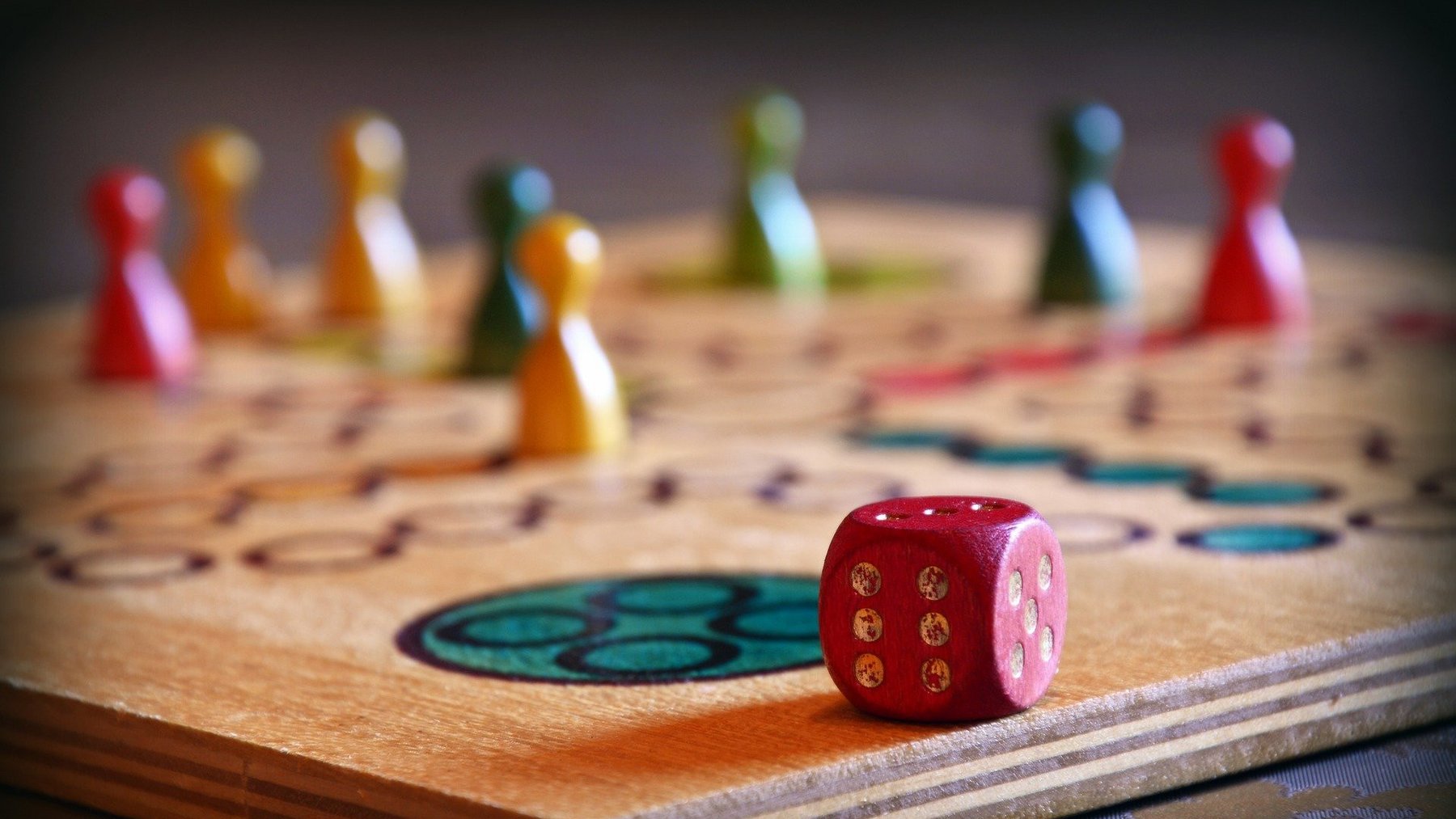 ein Mensch-Ärgere-Dich-Nicht-Spielbrett mit Figuren und Würfel