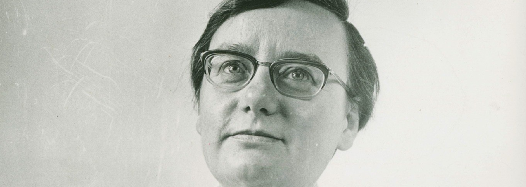 Christa Reinig, eckige Brille, kurzer Männerhaarschnitt, hat den Blick in die Ferne gerichtet.