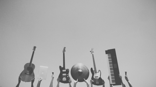 Musikinstrumente und Technik, die gegen einen klaren blauen Himmel in die Luft erhoben werden.