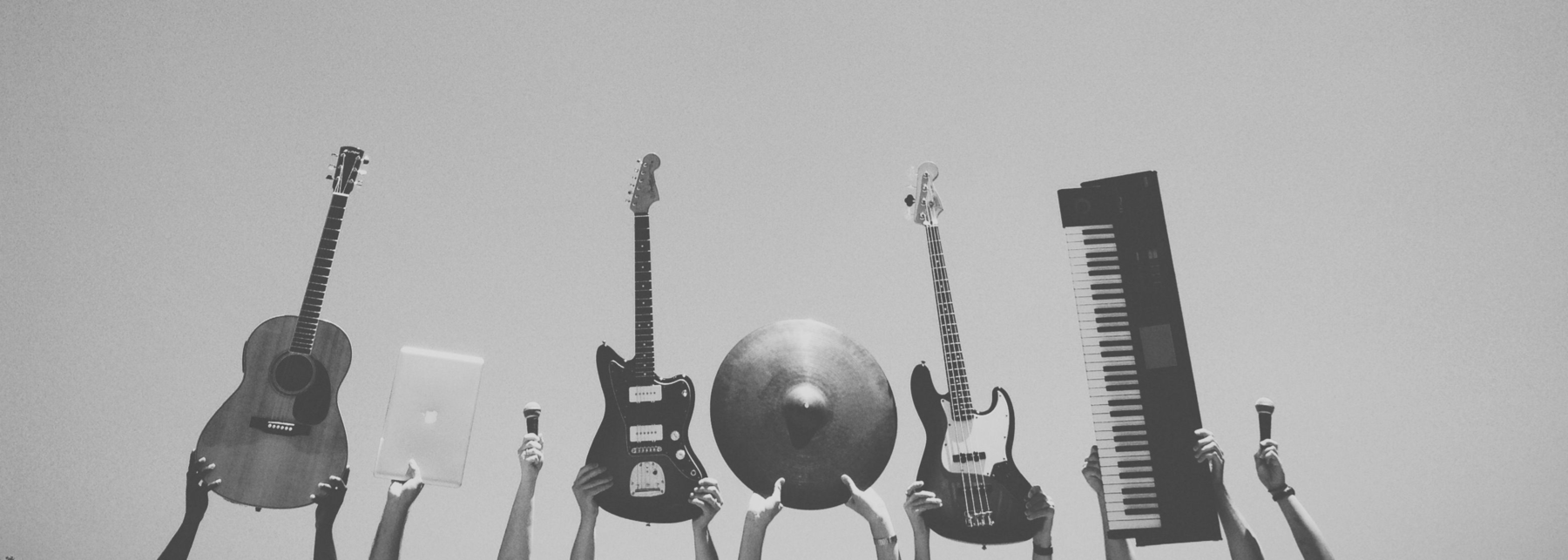 Musikinstrumente und Technik, die gegen einen klaren blauen Himmel in die Luft erhoben werden.
