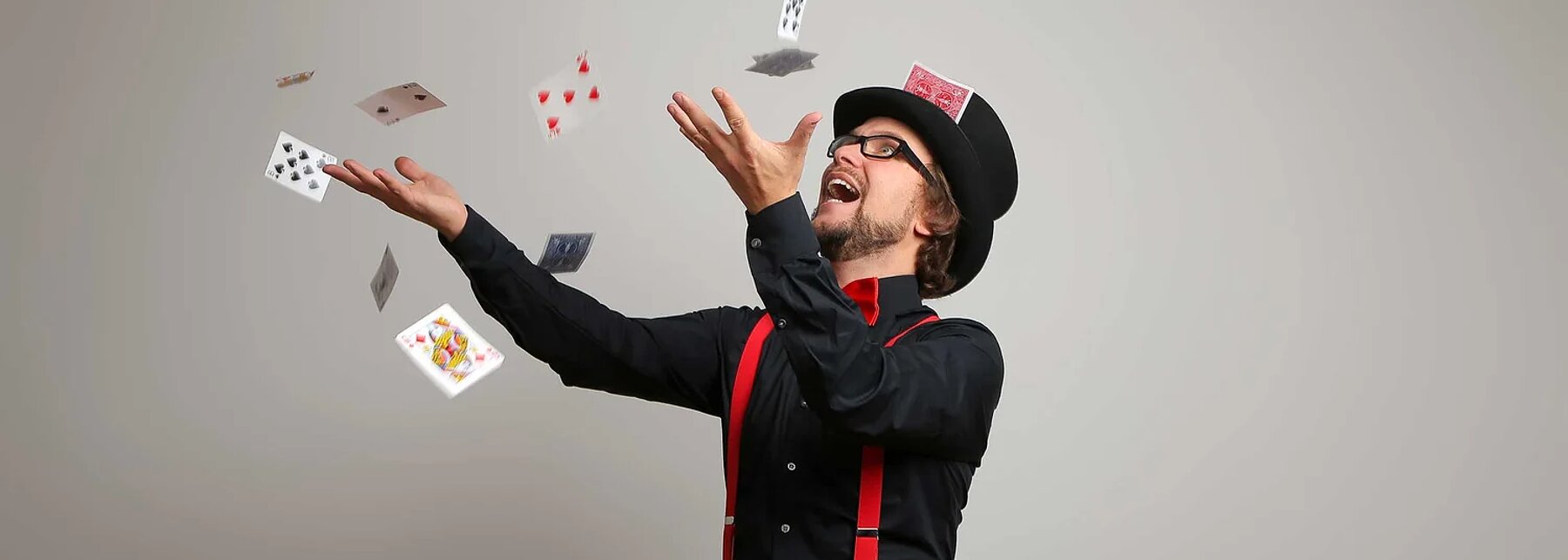 Zauberer Christaldo wirft Spielkarten in die Luft