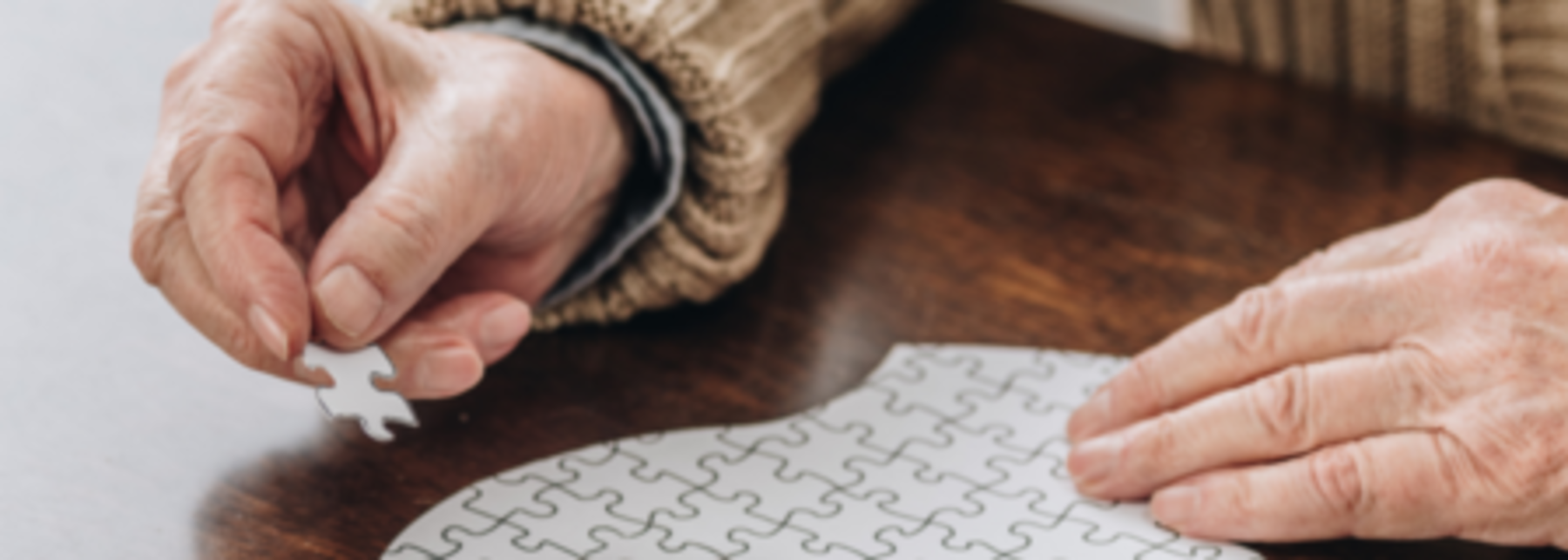 Senior*in legt ein Puzzle