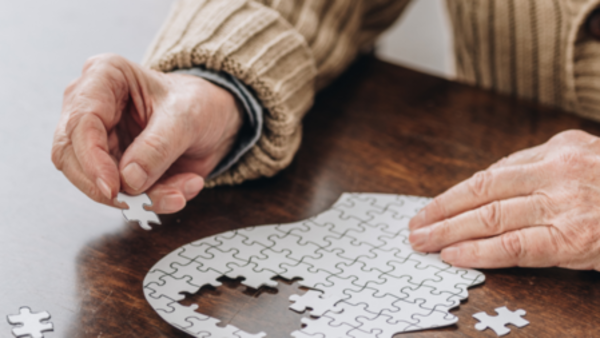 Senior*in legt ein Puzzle