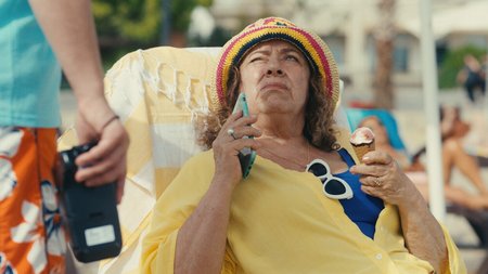 Ältere Frau im Liegestuhl am Strand