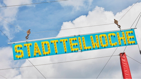 Schild mit Aufschrift "Stadtteilwoche"
