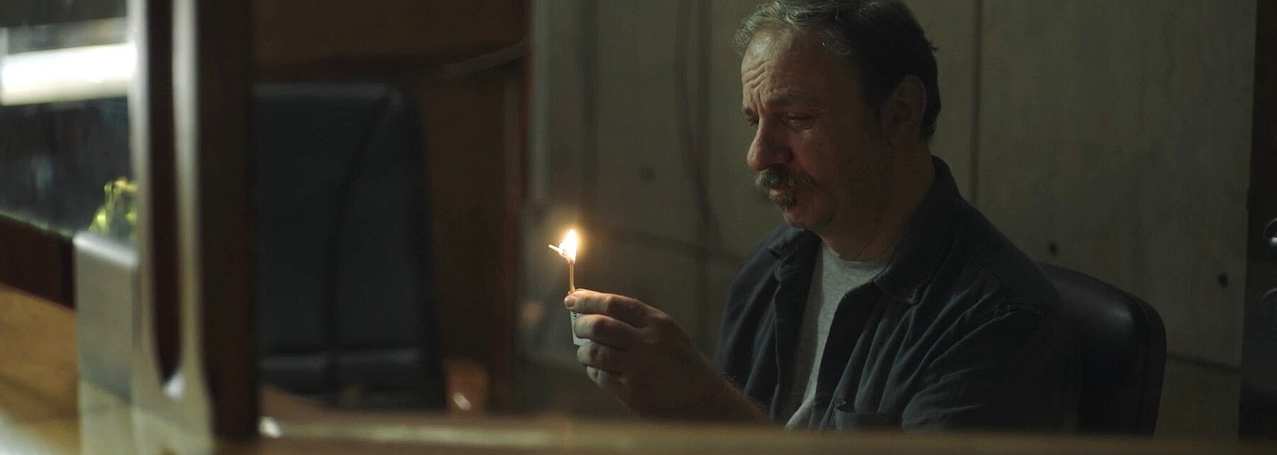 Filmstill - Mann mit brennendem Streichholz