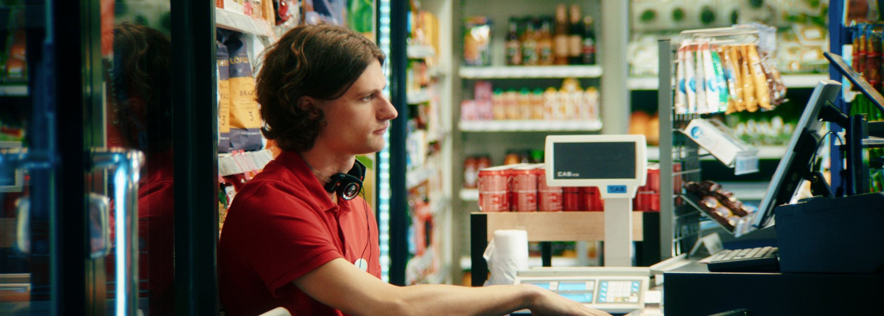 Junger Kassierer an der Supermarktkasse